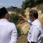 Kepala DPUTR Gresik Gunawan Setijadi (kanan) menerangkan kondisi longsor Bukit Pucem kepada Bupati Gus Yani. foto: ist.