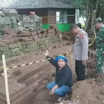 Ketua Tim Arkeolog BPCB Jatim M Andi Said (jongkok) menunjukkan bangunan candi yang ditemukan di pemakaman umum Desa Sukoreno.