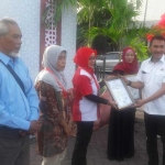 Kepala Departemen CSR Semen Indonesia, Wahjudi Heru saat menyerahkan sertifikat halal.