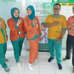 Para pegawai RSNU Tuban foto bersama sambil memamerkan sepatu kets yang dipakai.