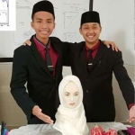 Muhammad Alief Dhafa Wahyudi bersama Akmalul Umam menunjukkan karya hijab anti kanker. Keduanya merupakan santri Pondok Pesantren Singa Putih Munfaridin, Dusun Sentong, Lumbangrejo, Prigen, Pasuruan.