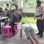 Salah satu pelanggar prokes sedang menjalani sanksi push up. (foto: Kominfo)