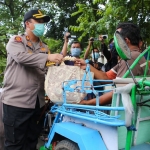 Kapolres Jombang saat memberikan paket sembako pada tukang becak.