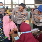 Wakapolres Gresik, Kompol Erika Purwana Putra saat memantau peserta baksos. Foto: SYUHUD/BANGSAONLINE.com