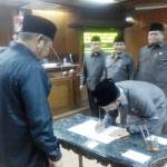 TEKEN: Ketua DPRD Sidoarjo H Sullamul Hadi Nurmawan meneken berita acara pengesahan lima Perda tentang Desa disaksikan Bupati H Saiful Ilah, saat rapat Paripurna, Kamis (23/6) petang. foto: MUSTAIN/ BANGSAONLINE