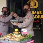 Kapolres Madiun Kota, AKBP Dewa Putu Eka Darmawan, saat menyerahkan potongan tumpeng kepada kasie humas.