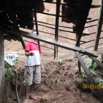 Ketua RT 19 Desa Bolo menunjukkan bagian rumah Yati yang terkena tanah longsor.