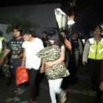 Salah satu pasangan mesum saat digiring dari vila ke dalam mobil untuk diangkut ke Pos Lantas 90 Alun-alun Batu. foto: ANIK/ BANGSAONLINE