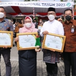 Wabup Aminatun Habibah bersama Kadisnaker Budi Rahardjo dan perwakilan perusahaan sedang menunjukkan penghargaan K3 dari Gubernur Jatim. foto: SYUHUD/ BANGSAONLINE