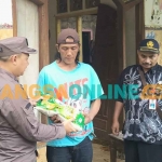 Kasi Intelijen Kejari Kabupaten Kediri, Iwan Nuzuardhi, saat menyerahkan bantuan kepada Janu, salah satu korban tanah longsor. Foto: MUJI HARJITA/BANGSAONLINE