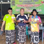 Sinyo Supit (kaos biru) saat menunjukkan uang bonus dari panitia Turnamen Tenis Meja Antarklub di Kediri. Foto: Ist