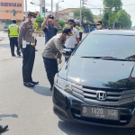 Kapolres Kediri Kota AKBP Miko Indrayana saat melakukan pemeriksaan langsung terhadap mobil pemudik. (foto: ist)