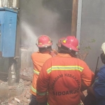 Para Petugas PMK Sidoarjo tampak sedang berusaha memadamkan api.