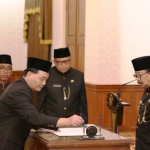 Pj Sekdaprov Jatim Jumadi menandatangani berita acara pelantikan di depan Gubernur Jatim Dr Soekarwo di Grahadi, tadi. 