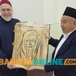 Prof Dr KH Asep Saifuddin Chalim, MA saat memberikan cendera mata berupa lukisan kepada Prof Dr Syaikh Muhammad Abdul Shomad Muhanna di kediamannya, Kairo, Mesir, Ahad (8/1/2023) malam. Foto: MMA/BANGSAONLINE