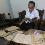 Agus Sulton saat menunjukkan kitab koleksinya. foto: RONY S/ BANGSAONLINE
