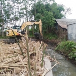 Alat berat diterjunkan untuk perbaikan irigasi yang rusak kena bencana banjir.