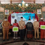 Bupati Bangkalan, R. Abdul Latif Amin saat menyerahkan bantuan dana hibah secara simbolis ke sejumlah penerima.