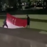 Tangkapan layar video dua orang pemuda mencoret bendera merah putih dengan tulisan RKUHAP di Taman Kota Negara, Kabupaten Jembrana, Provinsi Bali pada 18 November 2025 lalu
