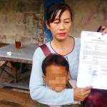 Juma’ati bersama anaknya, menunjukkan surat laporan ke polisi.