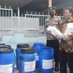 Kapolsek Sedati, Iptu Inda Purwati, saat mengenalkan budidaya ikan lele di dalam ember kepada Perangkat Desa Betro.