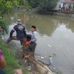 Warga saat mengevakuasi jasad FJ, bocah 12 tahun yang sebelumnya dilaporkan tenggelam di Sungai Pucang.