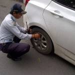 Petugas Dishub Gresik saat gembosi mobil yang parkir di Kawasan Tertib Lalu Lintas (KTL). foto: syuhud/harian bangsa