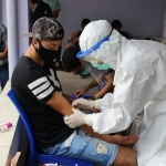 Petugas dengan APD lengkap saat mengambil sampel darah salah satu pemain Persik Kediri.