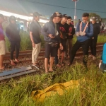 Petugas saat mengevakuasi korban tewas akibat tersambar kereta api di Sidoarjo.