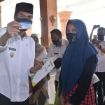 Penyerahan santunan secara simbolis dilakukan oleh Bupati Madiun, H. Ahmad Dawami kepada perwakilan anak yatim. (foto: ist).