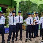 Kepala MTs Negeri 1 Tuban saat menyerahkan piala secara simbolis kepada para siswa.