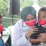 Wakil Ketua DPRD Jatim, Anik Maslachah bercengkerama dan memangku anak yatim yang ditinggal orang tuanya meninggal dunia karena Covid-19. foto: ist.