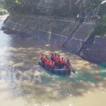 Tim basarnas sedang melakukan pencarian terhadap korban di sungai Bagong. foto: HERMAN SUBAGYO/ BANGSAONLINE