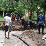 Camat Sangkapura Syamsul Arifin dan pejabat muspika gotong royong dengan warga membuat jembatan darurat. Foto: Ist.