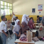 Para siswa dan wali murid SMAN 2 Kota Batu saling berpelukan dan berbagi bunga saat pembagian rapor.