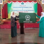 Serah terima bendera dan kunci kantor Fatayat NU dari ketua periode sebelumnya Ny. Hj. Nafidatul Qudsiyah (kanan) kepada ketua masa khidmat 2019-2024 Ny. Hj. Nur Anisyah.
