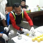Petugas saat melakukan cek urine di kantor Desa Candimulyo. foto: AAN AMRULLOH/ BANGSAONLINE