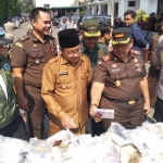 Kajari Kota Malang Amran Lakoni saat menunjukkan jumlah barang bukti ke Wali Kota Malang Sutiaji sebelum pemusnahan di halaman belakang Kejari Kota Malang, Selasa (09/07). foto: IWAN IRAWAN/ BANGSAONLINE
