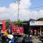 Dua mobil PMK tampak masih berada di depan Toko Bahan Bangunan Milik Warga Kanigaran, usai berhasil memadamkan api.