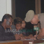 Petugas Satpol PP saat melakukan pendataan terhadap 34 orang pengamen, gelandangan, dan pengemis yang diamankan di kantor Kecamatan Durenan. foto: HERMAN S/ BANGSAONLINE