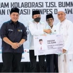 Direktur SDM dan Umum SIG Agung Wiharto bersama Menteri BUMN  Erick Thohir simbolis menyerahkan bantuan alat pembelajaran kepada ustadz M. Zaenal Arifin di Pondok Pesantren Qomaruddin, Kecamatan Bungah, Gresik. foto: ist.