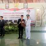 Pj. Bupati Pamekasan Masrukin saat menyerahkan SK perpanjangan masa jabatan kepada perwakilan kepala desa.