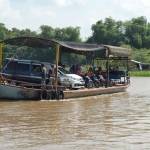 Perahu tambang yang sedang menyeberangi sungai Brantas sambil mengangkut kendaraan. foto: RONY S/ BANGSAONLINE