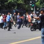 Seorang pelaku terlihat mengacungkan pistol setelah ledakan menghantam kawasan Jalan MH Thamrin, Jakarta Pusat, 14 Januari 2016. foto: KOMPAS