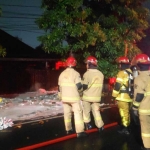 Petugas saat memadamkan api yang membakar muatan jasa kirim di dekat Markas Brimob, Jalan Gresikan, Surabaya.