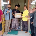 Koordinator Gusdurian Mojokutho Pare, Kabupaten Kediri, Antok Beler (nomor 2 dari kiri) saat menyerahkan bantuan di Desa Pucangsimo, Kecamatan Bandarkedungmulyo, Kabupaten Jombang. foto: ist.