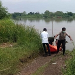 Petugas saat mengevakuasi mayat yang mengapung di Sungai Brantas.