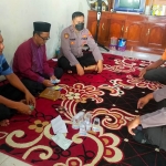 Bhabinkamtibmas Desa Katimoho Aipda Febriyanto bersama Kanit Binmas Polsek Kedamean Aipda Eko Subandi saat mendatangi rumah duka Almarhum Andik Suyanto. foto: ist.