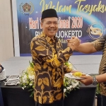 Ketua PWI Mojokerto saat memberikan potongan nasi kuning ke H. Pungkasiadi Bupati Mojokerto.