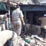 Petugas Dispol PP Pemkab Gresik saat merobohkan bangunan liar. foto: SYUHUD/ BANGSAONLINE